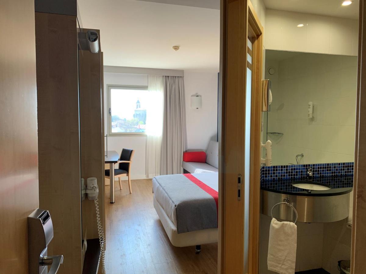 Habitación Doble Estándar con cama doble grande y sofá cama.
