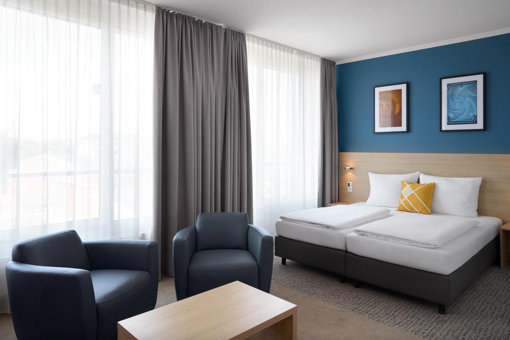 Geräumiges Standard Zimmer mit Kingsize-Bett und Blick auf den Innenhof
