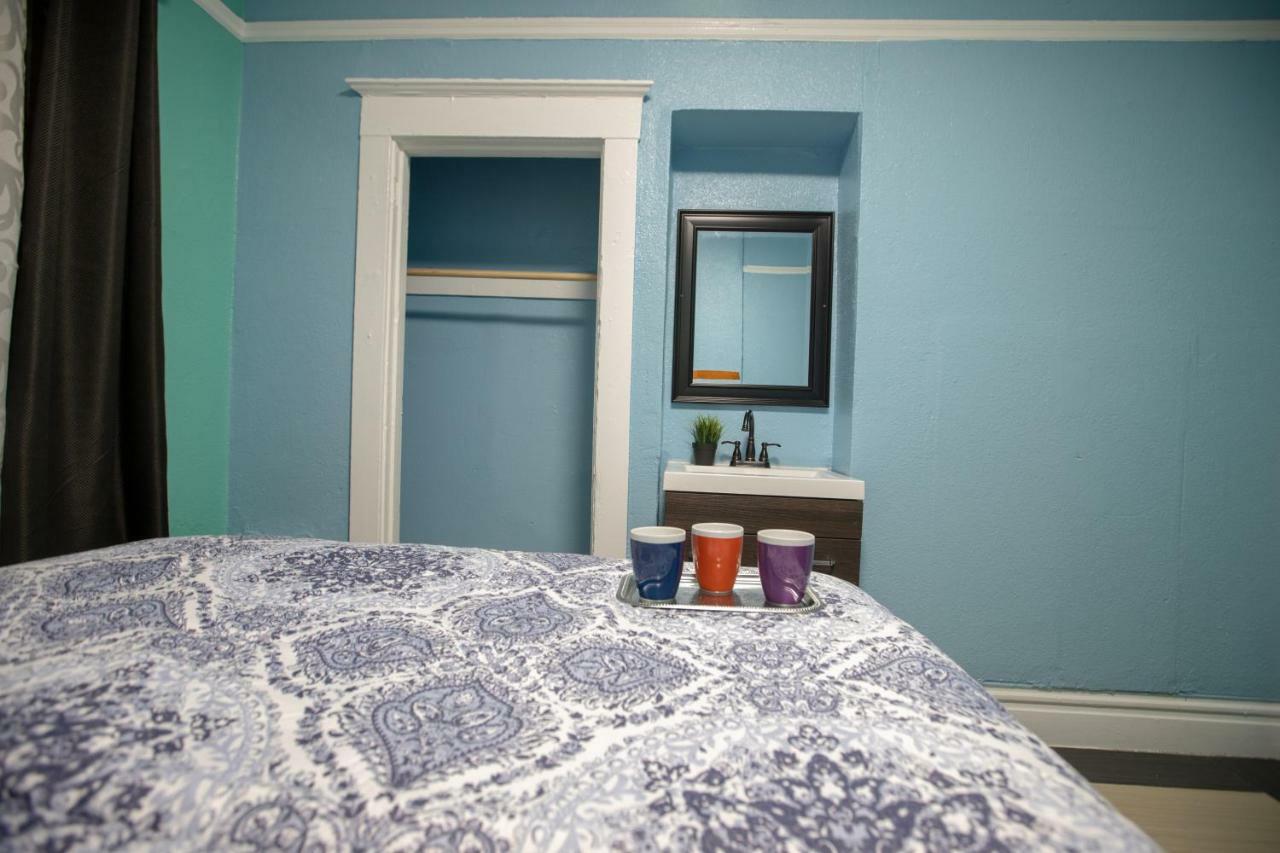 Habitación con cama grande y baño compartido en el pasillo